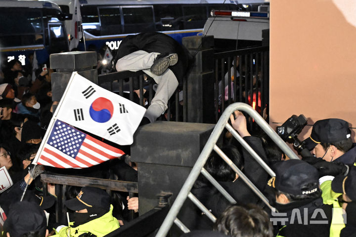 [서울=뉴시스] 김근수 기자 = 내란 수괴와 직권남용 등의 혐의를 받는 윤석열 대통령의 구속 전 피의자 심문(영장실질심사)이 열린 18일 서울 마포구 서울서부지방법원에서 윤 대통령 지지자들이 담장 너머에서 시위를 하고 있다. (공동취재) 2025.01.18. photo@newsis.com