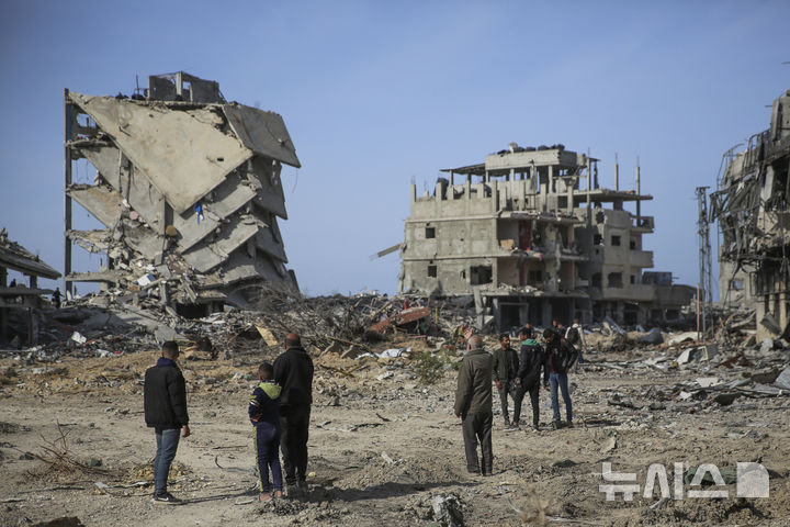 [라파=AP/뉴시스] 이스라엘과 하마스의 휴전이 발효된 19일(현지 시간) 가자지구 라파에서 팔레스타인 주민들이 이스라엘의 공습과 지상 공격으로 파괴된 건물 잔해를 살피고 있다. 2025.01.20.