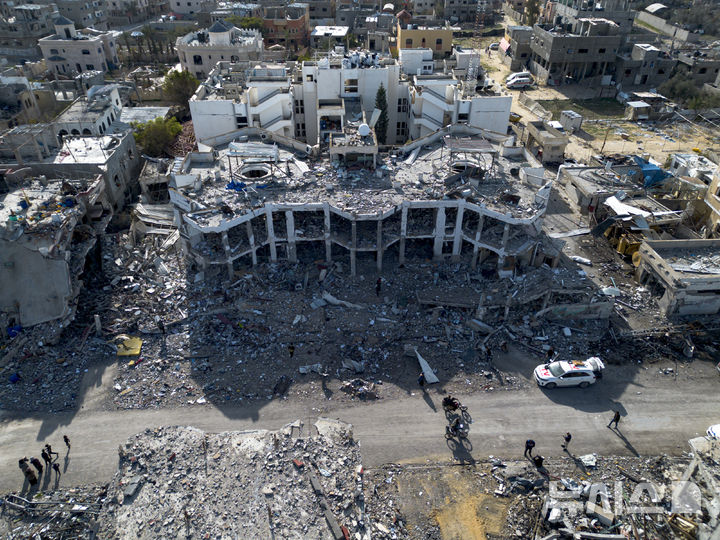 [라파=AP/뉴시스] 이스라엘과 하마스의 휴전이 발효된 19일(현지 시간) 가자지구 라파에서 팔레스타인 주민들이 이스라엘의 공습과 지상 공격으로 파괴된 건물 잔해 옆으로 지나가고 있다. 2025.01.20.