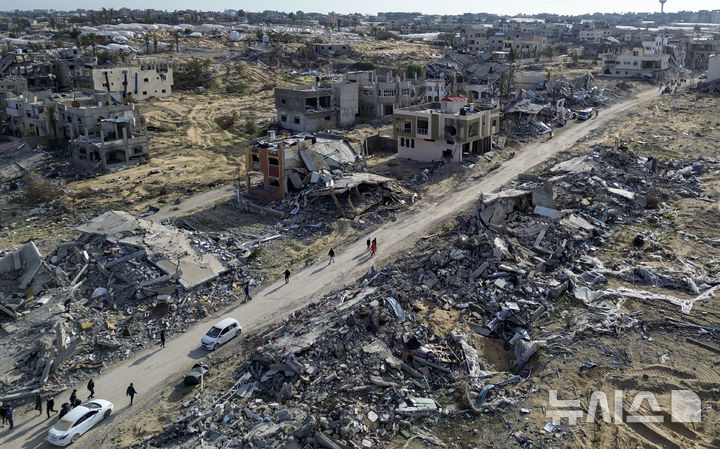 [라파=AP/뉴시스] 이스라엘과 하마스의 휴전이 발효된 19일(현지 시간) 가자지구 라파에서 팔레스타인 주민들이 이스라엘의 공습과 지상 공격으로 파괴된 건물 잔해를 살피고 있다. 2025.01.20.