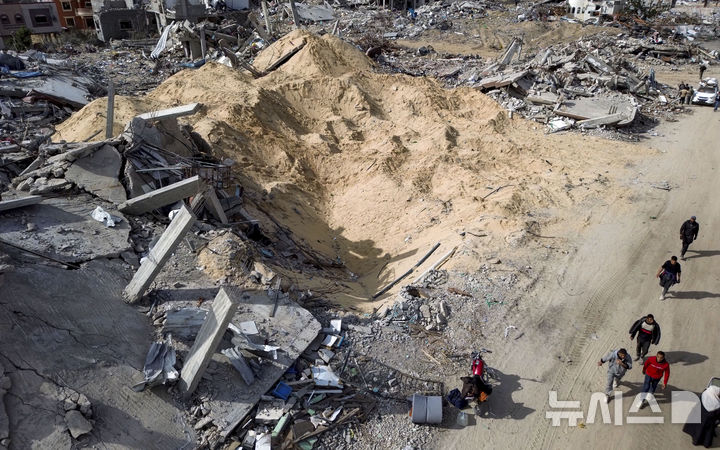 [라파=AP/뉴시스] 이스라엘과 하마스의 휴전이 발효된 19일(현지 시간) 가자지구 라파에서 팔레스타인 주민들이 이스라엘의 공습과 지상 공격으로 파괴된 건물 잔해를 살피고 있다. 2025.01.20.