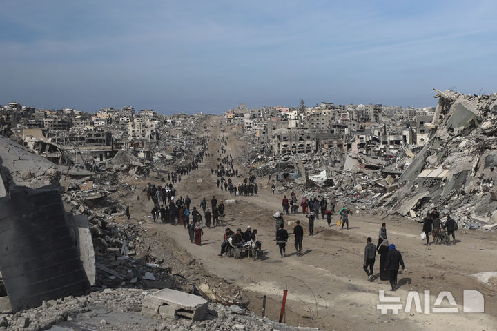 [자발리야=AP/뉴시스] 이스라엘과 하마스의 휴전이 발효된 19일(현지 시간) 가자지구 북부 자발리야라에서 팔레스타인 주민들이 이스라엘의 공습과 지상 공격으로 파괴된 건물 잔해 사이를 걷고 있다. 2025.01.20.