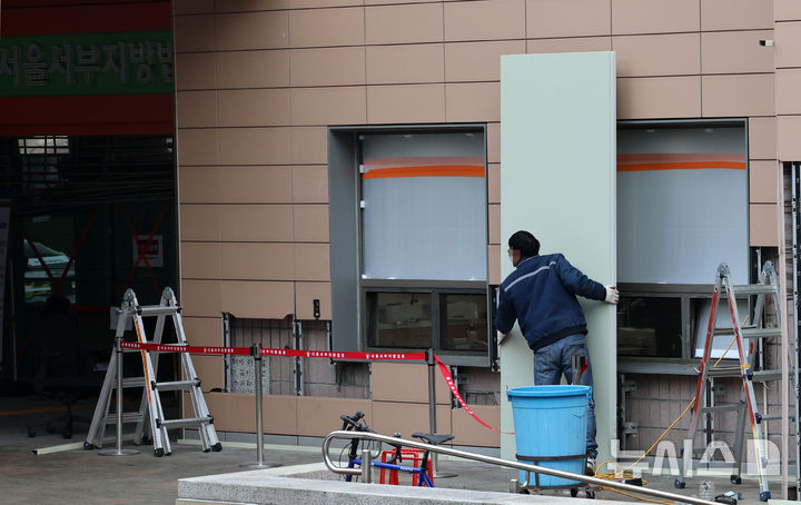 [서울=뉴시스] 이영환 기자 = 20일 오전 서울 마포구 서울서부지방법원에서 공사 관계자들이 파손된 외벽에 보수작업을 하고 있다.지난 19일 새벽 윤석열 대통령의 구속영장 발부에 지지자들이 집단 폭력 및 법원 안으로 침입하는 사고가 발생했다. 한편 서울서부지방법원은 법원은 정상적으로 운영될 것이라고 밝혔다. 다만 차량을 통한 출입은 불가능하고 출입자는 신분 확인이 필요하다고 전했다.&nbsp; 2025.01.20. 20hwan@newsis.com