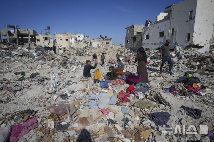 [라파=AP/뉴시스] 이스라엘과 하마스 간의 휴전 협정이 발효된 지 하루가 지난 20일(현지 시간) 가자지구 라파로 돌아온 팔레스타인 난민 가족이 파괴된 자택 잔해 속에서 쓸만한 물건을 찾고 있다. 2단계 휴전을 위한 협상이 준비 절차에 돌입한 것으로 알려졌다. 2025.01.23.
