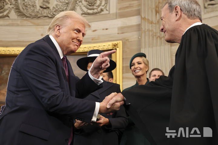 [워싱턴=AP/뉴시스] 도널드 트럼프(왼쪽) 미국 대통령이 지난 1월 20일(현지 시간) 미 연방의회 의사당 로툰다 홀에서 취임 선서를 마친 후 존 로버츠 연방대법원장과 악수하고 있다. 2025.03.19.