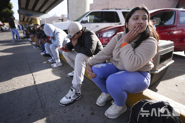 [티후아나=AP/뉴시스] 베네수엘라 이민자가 20일(현지 시간) 멕시코 티후아나의 국경 검문소에서 미국 세관국경보호국(CBP)의 CBP One 앱의 입국·망명 예약이 취소된 것을 확인한 뒤 슬픔에 잠겨있다. 미국 세관국경보호국(CBP)는 이날 이민 희망자들의 입국·망명 신청을 예약할 수 있도록 한 CBP One 앱의 가동을 중단했다. 2025.01.21.