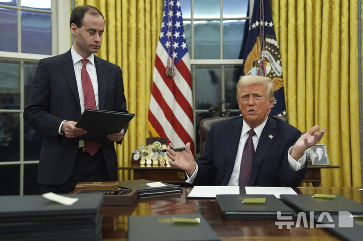 [워싱턴=AP/뉴시스]도널드 트럼프 미국 대통령이 20일(현지 시간) 백악관 입성 후 오벌오피스에서 각종 행정명령에 서명하고 있다. 2025.01.21.