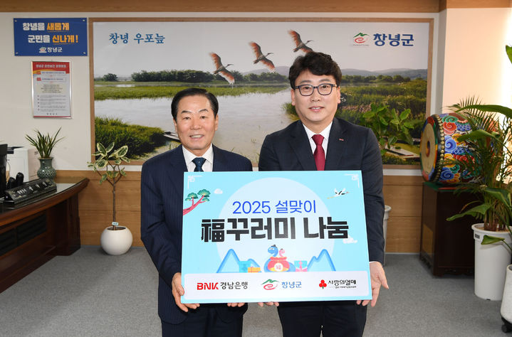 [창녕=뉴시스] 서철환(오른쪽) BNK경남은행 창녕지점장이 사랑 나눔 사업인 생필품 복꾸러미를 성낙인 군수에게 전달하고 있다. (사진= 창녕군 제공) 2025.01.21. photo@newsis.com *재판매 및 DB 금지