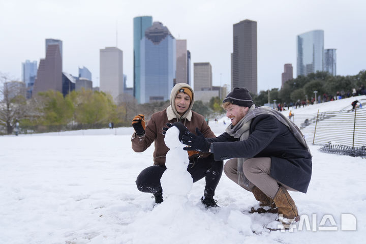 [휴스턴=AP/뉴시스] 21일(현지 시간) 미 텍사스주 휴스턴에서 시민들이 눈사람을 만들고 있다. 미 기상청(NWS)은 텍사스주, 루이지애나주, 미시시피주, 조지아주 등 남부 지역에 이례적인 겨울 폭풍이 덮쳐 겨울 폭풍 경보를 발령했다. 2025.01.22.