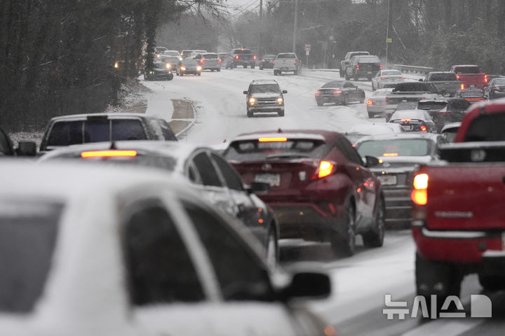 [조지아=AP/뉴시스] 21일(현지 시간) 미 조지아주 터커에 눈이 내린 가운데 차량들이 서행하고 있다. 미 기상청(NWS)은 텍사스주, 루이지애나주, 미시시피주, 조지아주 등 남부 지역에 이례적인 겨울 폭풍이 덮쳐 겨울 폭풍 경보를 발령했다. 2025.01.22.