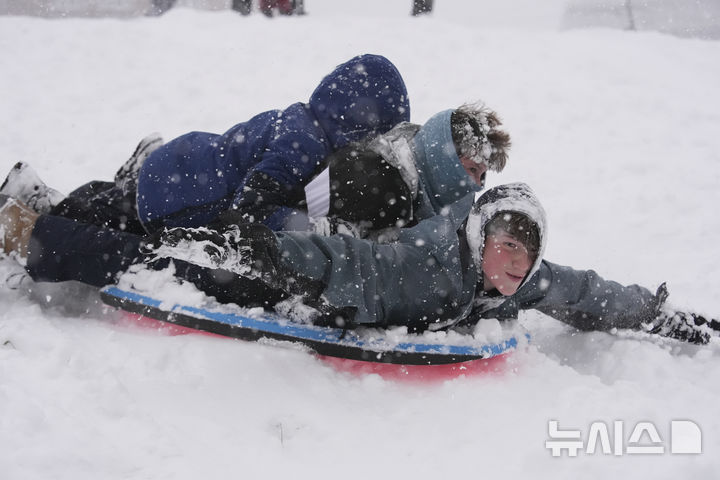 [뉴올리언스=AP/뉴시스] 21일(현지 시간) 미 뉴욜리언스에서 시민들이 눈을 맞으며 썰매를 타고 있다. 미 기상청(NWS)은 텍사스주, 루이지애나주, 미시시피주, 조지아주 등 남부 지역에 이례적인 겨울 폭풍이 덮쳐 겨울 폭풍 경보를 발령했다. 2025.01.22.