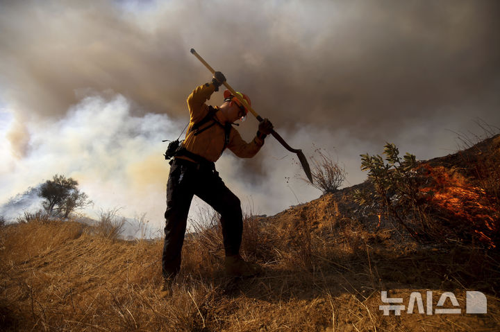 [캘리포니아주=AP/뉴시스] 22일(현지 시간) 미국 캘리포니아주 로스앤젤레스 캐스테익 인근에서 '휴즈 산불'이 발생해 소방대원이 화재 진압을 하고 있다. 2025.01.23.