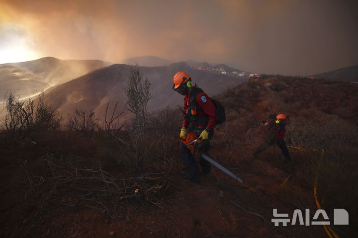 [캘리포니아주=AP/뉴시스] 22일(현지 시간) 미국 캘리포니아주 로스앤젤레스 캐스테익 인근에서 '휴즈 산불'이 발생해 소방대원들이 화재 진압을 하고 있다. 2025.01.23.