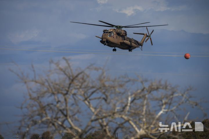 [이스라엘 남부=AP/뉴시스] 25일(현지 시간) 가자지구 국경 인근 이스라엘 남부에 이날 석방된 여군 4명을 태운 헬기가 착륙하고 있다. 2025.01.25.