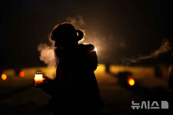 [테레진=AP/뉴시스] 27일(현지 시간) 국제 홀로코스트 희생자 추모의 날을 맞아 체코 테레진에 있는 옛 나치 강제수용소에서 한 여성이 촛불을 들고 있다. 테레진 수용소에는 제2차 세계대전 약 15만5천 명의 체코 유대인이 이곳에 수용됐고 그 중 약 3만5천 명이 사망했다. 2025.01.28.