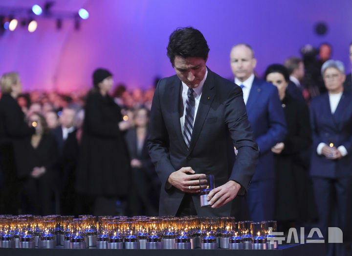 [오슈비엥침=AP/뉴시스] 쥐스탱 트뤼도 캐나다 총리가 27일(현지 시간) 폴란드 오슈비엥침에 있는 아우슈비츠-비르케나우 옛 나치 강제수용소에서 열린 아우슈비츠 해방 80주년 기념식에 참석해 촛불을 놓고 있다. 국제연합(UN)은 1월 27일을 1945년 아우슈비츠 강제수용소가 해방된 것을 기념해 국제 홀로코스트 희생자 추모의 날로 지정했다. 2025.01.28.