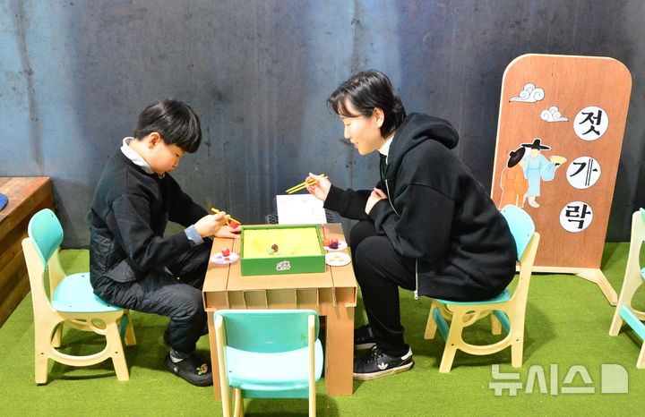 [청주=뉴시스] 서주영 기자 = 설 연휴 기간인 28일 충북 청주시 청원구 내덕동의 동부창고 카페C를 찾은 시민이 젓가락 집기 놀이를 즐기고 있다. 2025.01.28. juyeong@newsis.com