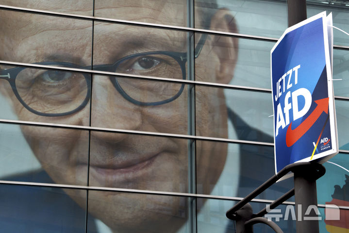 [베를린=AP/뉴시스] 지난달 29일(현지 시간) 독일 베를린 기독민주당(CDU) 당사에 걸린 리드리히 메르츠 총리 후보의 대형 현수막 앞에 극우 독일대안당(AfD)의 선거 포스터가 가로등에 부착돼 있다. 2025.02.18. 