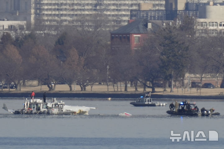 [알링턴=AP/뉴시스] 30일 오전(현지 시간) 미 워싱턴DC 로널드 레이건 공항 인근 포토맥강에서 구조대가 여객기 추락 현장을 수색하고 있다. 전날 오후 아메리칸항공 산하 PSA항공 여객기가 이 공항에 착륙을 시도하다가 훈련 중이던 미 육군의 블랙호크 헬기와 충돌 후 추락해 여객기 탑승자 64명 헬기 탑승자 3명 전원이 사망한 것으로 알려졌다. 2025.01.31.