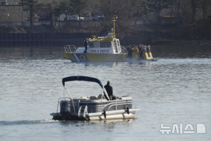 [알링턴=AP/뉴시스] 30일 오전(현지 시간) 미 워싱턴DC 로널드 레이건 공항 인근 포토맥강에서 구조대가 여객기 추락 현장을 수색하고 있다. 전날 오후 아메리칸항공 산하 PSA항공 여객기가 이 공항에 착륙을 시도하다가 훈련 중이던 미 육군의 블랙호크 헬기와 충돌 후 추락해 여객기 탑승자 64명 헬기 탑승자 3명 전원이 사망한 것으로 알려졌다. 2025.01.31.