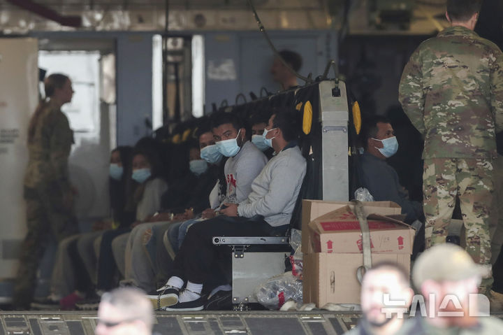 [엘패소=AP/뉴시스] 30일(현지 시간) 미 텍사스주 엘패소의 포트 블리스 기지에서 마스크를 쓴 불법 이민자들이 손과 발에 족쇄를 찬 채 군용기에 앉아 과테말라로 추방을 기다리고 있다. 2025.01.31.
