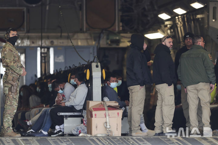 [엘패소=AP/뉴시스] 지난달 30일(현지 시간) 미 텍사스주 엘패소의 포트 블리스 기지에서 마스크를 쓴 불법 이민자들이 손과 발에 족쇄를 찬 채 군용기에 앉아 과테말라로 추방을 기다리고 있다. 2025.02.01.