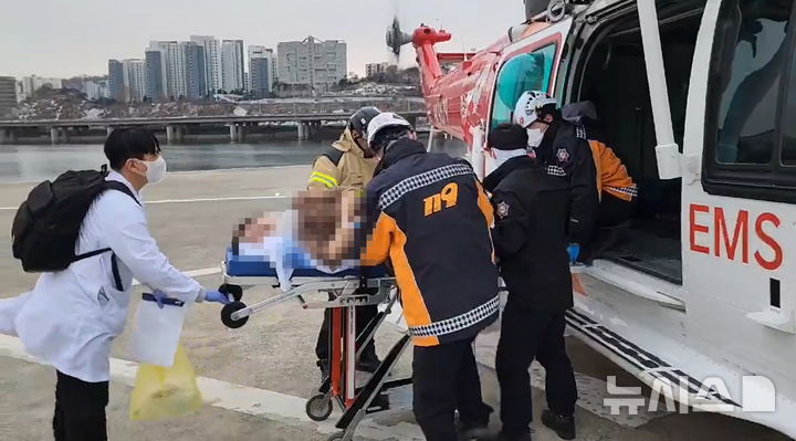 [서울=뉴시스]30일 낮 진주 경상국립대학교병원 헬리패드에서 출발해 서울 노들섬 헬리패드에 도착한 경남119항공대 소방헬기에서 구급대원과 의료진이 응급환자를 옮기고 있다.(사진=경남소방본부 제공)2025.01.31. photo@newsis.com
