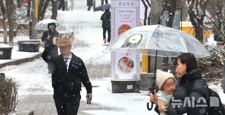 [인천=뉴시스] 전진환 기자 = 눈이 내리던 지난달 31일 오후 인천 남동구 구월동의 한 거리에서 시민들이 우산을 쓰고 걸어가고 있다. 2025.01.31. amin2@newsis.com