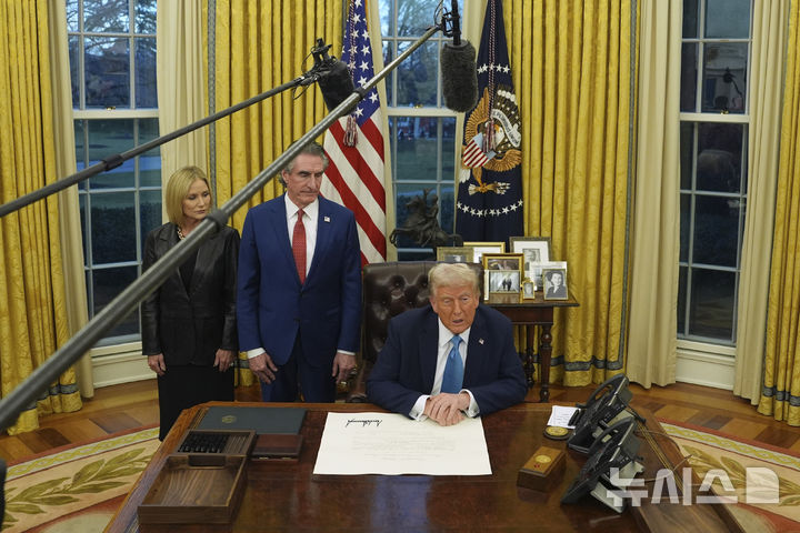 [워싱턴=AP/뉴시스]도널드 트럼프 미 대통령이 31일(현지시각) 백악관 집무실에서 더그 버검 내무부장관 부부를&nbsp; 옆에 두고 기자들에게 발언하고 있다. 2025.2.1.