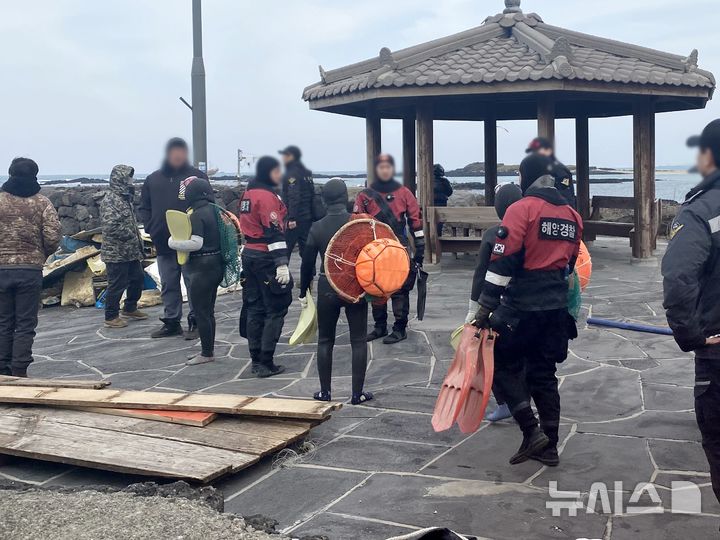 [제주=뉴시스] 2일 제주시 구좌읍 하도리 해안가에서 해녀들이 해경 구조대원과 함께 실종 선원 수색을 위해 입수 전 회의를 하고 있다. 이날 해녀들은 수중에서 30대 인도네시아 선원을 발견했고, 해경이 수습했다. (사진=제주도 제공) 2025.02.03. photo@newsis.com