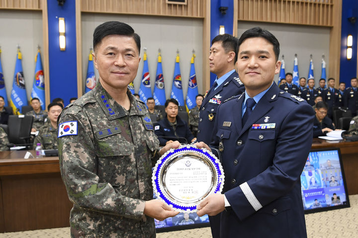 [서울=뉴시스] 이영수 공군참모총장이 '조직운영 발전' 부문에 선정된 '공군본부 정훈실 미디어콘텐츠과'의 김세현 미디어콘텐츠과장(중령)에게 상패를 수여하고 기념촬영하고 있다. (사진=공군 제공) 2025.02.03. photo@newsis.com *재판매 및 DB 금지