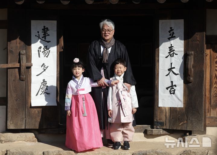 [서울=뉴시스] 김명년 기자 = 절기상 입춘(立春)인 3일 오전 서울 종로구 국립민속박물관 오촌댁 대문에서 서예가와 어린이들이 입춘첩을 붙이고 기념촬영하고 있다. 2025.02.03. kmn@newsis.com