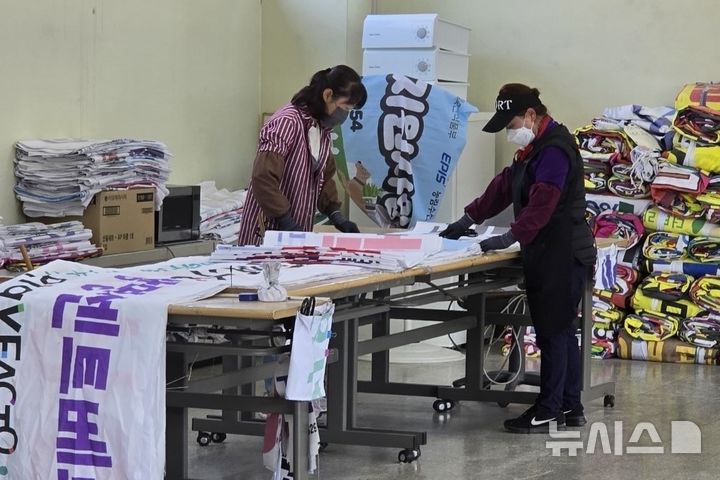 [광명=뉴시스]공공일자리 참여자들이 광명시가 2024년 상반기 공공일자리 사업의 일환으로 진행한 폐현수막 재활용사업에 참여해 폐현수막을 재단하고 있다.(사진=광명시 제공)2025.02.04.photo@newsis.com