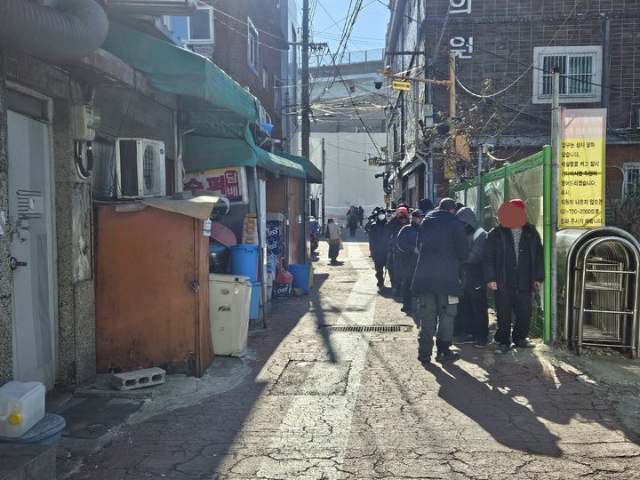[서울=뉴시스]이명동 기자 = 4일 오전 서울 영등포구 영등포역 6번 출구 앞 급식소인 토마스의 집 이용을 원하는 방문자가 개장 전 옆 골목에서 기다리고 있다. 전국 대부분 지역에 한파특보가 이날 따뜻한 국물과 김이 피어오르는 쌀밥을 찾아온 쪽방촌 주민 등 60여 명은 토마스의 집 운영 전부터 줄지어 서서 급식소 개장을 기다렸다. 2025.02.04. ddingdong@newsis.com *재판매 및 DB 금지