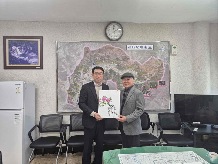 [밀양=뉴시스] 박해대(오른쪽) 작가가 산내면 행정복지센터를 방문해 조정제 면장에게 캘리그라피 작품을 기증하고 있다. (사진= 밀양시 제공) 2025.02.04. photo@newsis.com *재판매 및 DB 금지