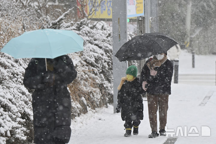 [광주=뉴시스] 광주 도심에서 한 아이가 엄마 손을 잡고 조심스레 눈길을 걷고 있다. (사진=뉴시스DB) pboxer@newsis.com