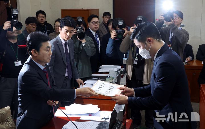 [서울=뉴시스] 조성봉 기자= 안규백 국조특위 위원장이 4일 오전 서울 여의도 국회에서 열린 '윤석열 정부의 비상계엄 선포를 통한 내란 혐의 진상규명 국정조사 특별위원회' 청문회에서 불출석한 윤 대통령에 대한 동행명령장을 국회 경위에게 전달하고 있다. 2025.02.04. suncho21@newsis.com