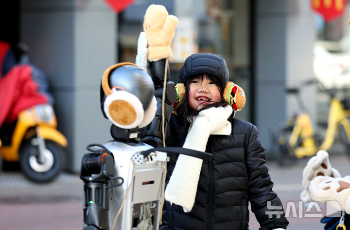 [대구=뉴시스] 이무열 기자 = 다음 주(10일~16일)는 제주, 전남, 경남 등에 비가, 중부지방 등에는 비나 눈이 오겠다. 사진은 전국 대부분 지역이 영하권 날씨를 보인 지난 4일 대구 중구 동성로에서 한 어린이가 귀마개를 착용한 휴먼로봇과 인사하고 있는 모습. 2025.02.04. lmy@newsis.com