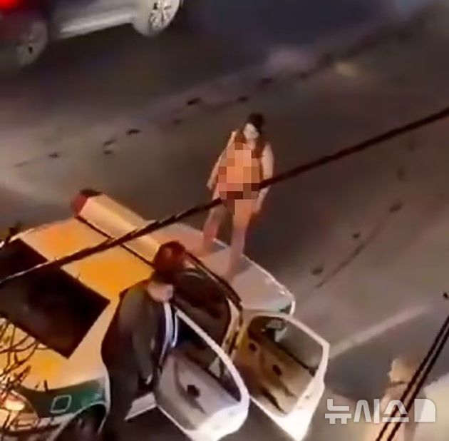 [서울=뉴시스] 이란의 한 여성이 알몸 상태로 경찰 차 위에 올라탔다. (사진=데일리메일)