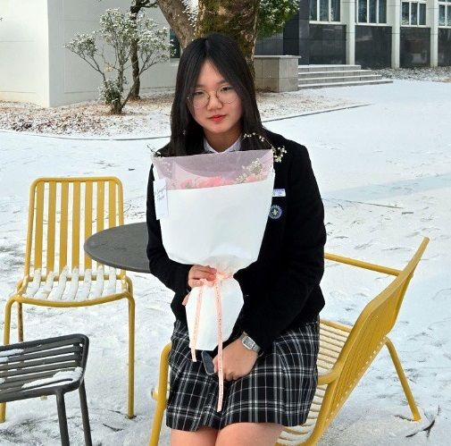 [칠곡=뉴시스] 순심교육재단이사장 표창을 받은 윤가은(순심여중 3년) 학생이 꽃다발을 들고 교정에서 기념사진을 찍고 있다 (사진=칠곡군 제공) 2025.02.09 photo@newsis.com *재판매 및 DB 금지