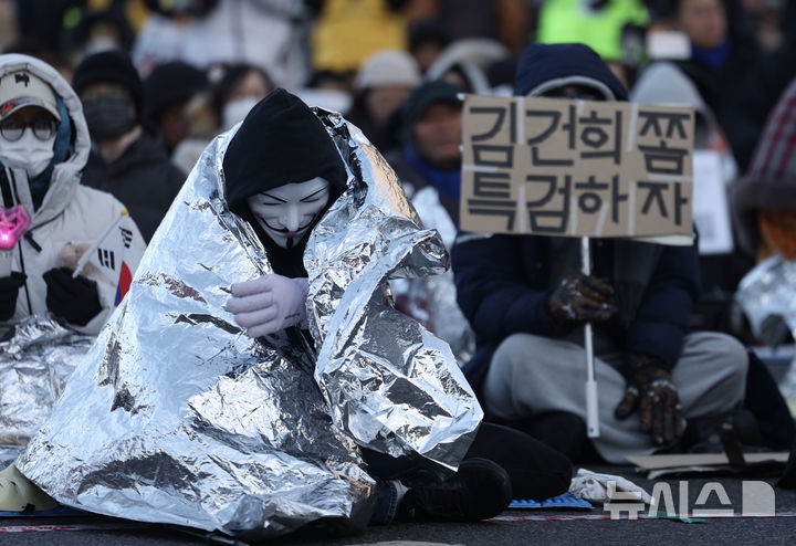 [서울=뉴시스] 김명년 기자 = 8일 오후 서울 종로구 경복궁역 인근에서 열린 ‘제10차 윤석열 즉각 퇴진! 사회대개혁! 범시민대행진’ 집회에서 참가자가 방한비닐을 덮고 있다. 2025.02.08. kmn@newsis.com