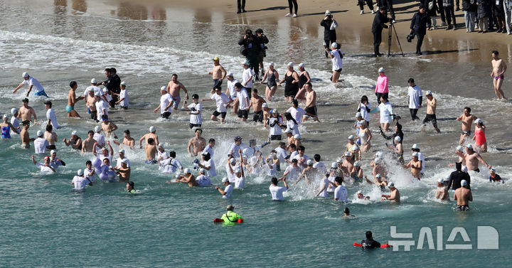 [부산=뉴시스] 하경민 기자 = '제38회 부산 북극곰 축제'가 열린 9일 부산 수영구 광안리해수욕장에서 시민과 관광객 등 인간 북극곰들이 차가운 겨울바다에 뛰어들고 있다. 2025.02.09. yulnetphoto@newsis.com
