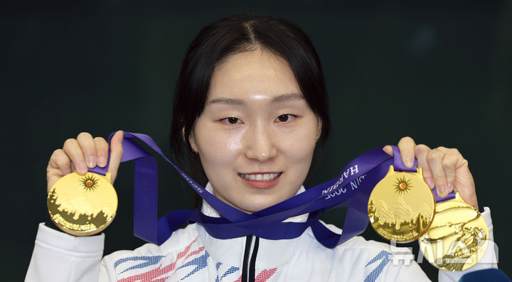 [인천공항=뉴시스] 김근수 기자 = 2025 하얼빈 동계아시안게임에서 3관왕을 차지한 쇼트트랙 최민정이 10일 인천국제공항 제1여객터미널 입국장에서 메달을 들어 보이고 있다. 2025.02.10. ks@newsis.com