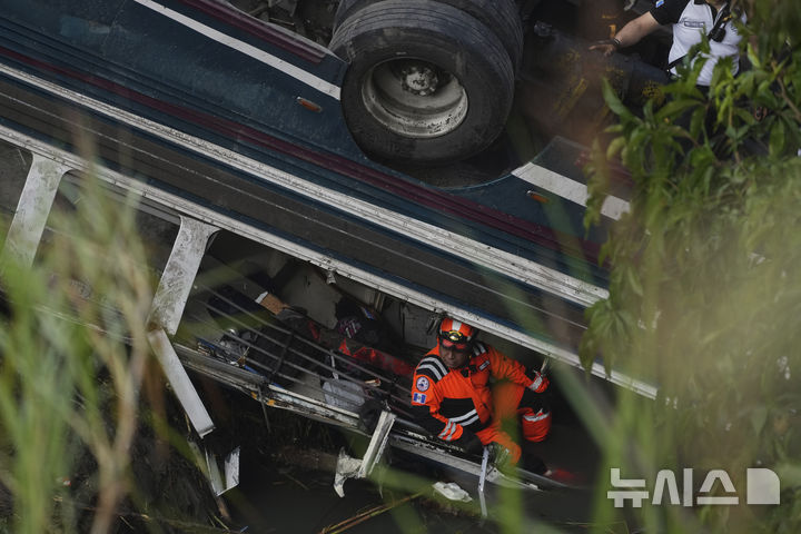 [과테말라시티=AP/뉴시스] 10일(현지 시간) 과테말라 수도 과테말라시티 외곽 버스 추락 현장에서 소방구조대가 희생자를 수색하고 있다. 이날 새벽 70여 명이 탑승한 버스가 다리를 지나다가 수십 미터 아래 하천으로 추락해 지금까지 51명이 숨진 것으로 알려졌다. 2025.02.11.