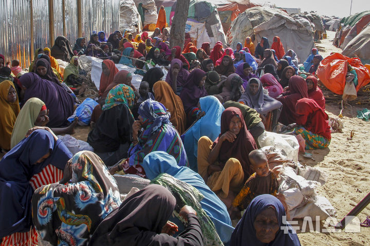 [모가디슈( 소말리아)=AP/뉴시스] 소말리아에서 계속되는 심한 가뭄으로 집을 떠난 피난민들이 2월 4일 수도 모가디슈 교외의 임시 수용소에서 구호식을 기다리고있다. 가뭄은 더욱 심해지고 있어 12월 현재 460만명의 이재민이 발생했고 내년 1월 건기가 시작되면 최악의 사태가 될 것으로 유엔은 우려하고 있다. 2025. 12. 23.&nbsp; 