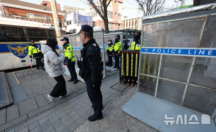 [서울=뉴시스] 고범준 기자 = 윤석열 대통령 탄핵 심판 7차 변론기일인 11일 오전 서울 종로구 헌법재판소 인근에서 경찰이 시민들에게 길 안내를 하고 있다. 2025.02.11. bjko@newsis.com