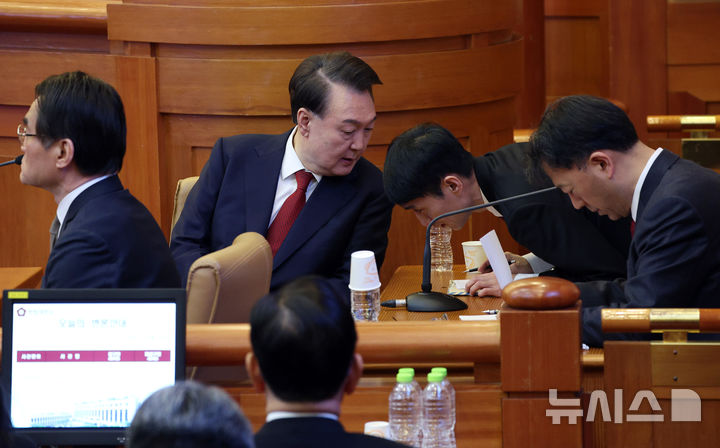 [서울=뉴시스] 사진공동취재단 = 윤석열 대통령이 11일 서울 종로구 헌법재판소에서 열린 탄핵심판 7차 변론기일에 출석해 변호인과 대화하고 있다. 2025.02.11. photo@newsis.com