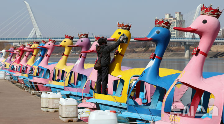 [대구=뉴시스] 이무열 기자 = 추위가 다소 풀린 11일 대구 동구 동촌유원지 오리배 선착장에서 관리인이 겨우내 묵은 때를 청소하고 있다. 2025.02.11. lmy@newsis.com