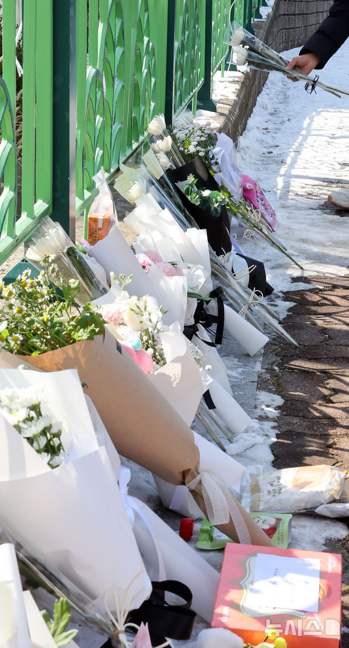 [대전=뉴시스] 강종민 기자 = 11일 오후 초등학생 피살사건이 발생한 대전 서구 관저동의 한 초등학교 정문 옆 담장에서 시민들이 국화꽃과 과자·음료 등을 놓으며 고 김하늘(8) 양을 추모하고 있다. 2025.02.11. ppkjm@newsis.com