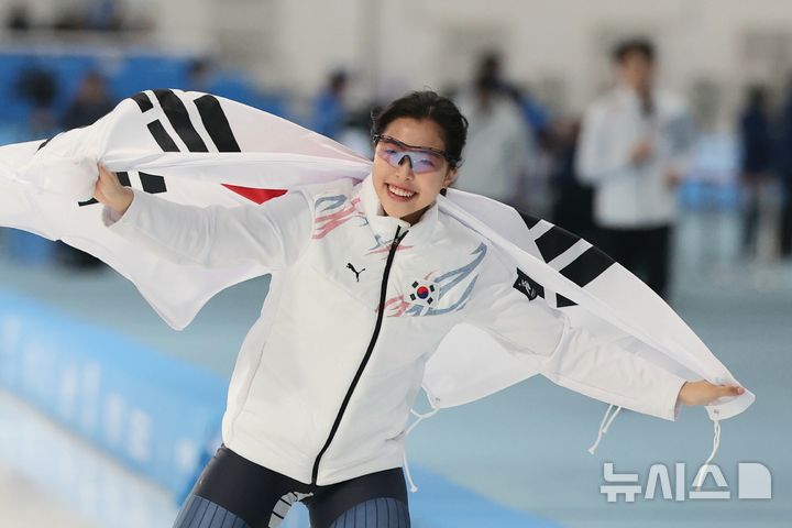 [하얼빈(중국)=뉴시스] 김선웅 기자 = 11일(현지 시간) 중국 하얼빈 헤이룽장 스피드스케이팅 오벌에서 열린 2025 하얼빈 동계 아시안게임 스피드스케이팅 여자 1000m 경기에서 동메달을 획득한 이나현이 태극기를 두르고 세레머니를 하고 있다. 2025.02.11. mangusta@newsis.com